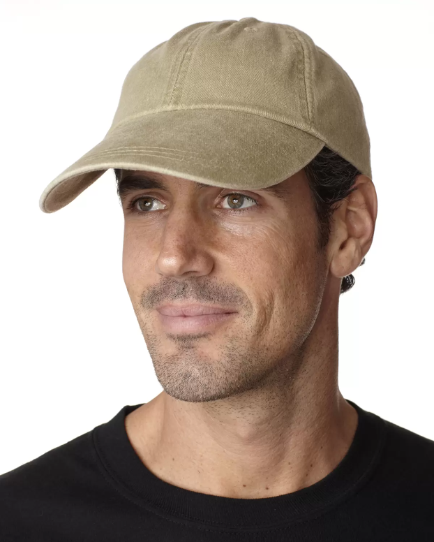 A man wearing a plain beige baseball cap with a curved brim and a black shirt.